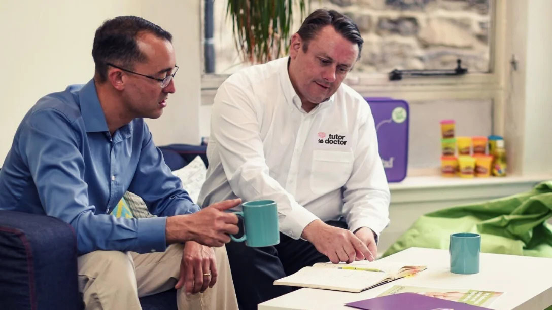 two colleagues reviewing documents over coffee