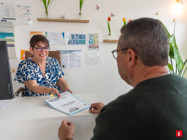 accueil À la réception : conseillère souriante remet documents