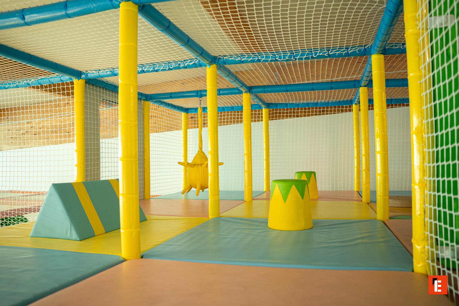 aire de jeux intérieure sécurisée avec filet et tapis pastel