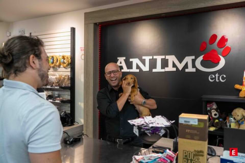 homme souriant en animalerie avec petit chien près de la caisse