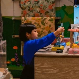 bambino in maglione blu esplora giocattoli meccanici