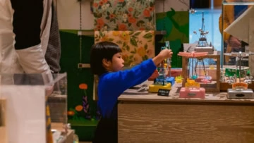 bambino in maglione blu esplora giocattoli meccanici