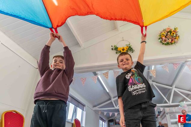boys playing with colorful parachute