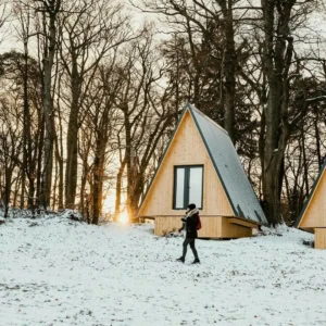 cabanes en bois à la lisière enneigée au soleil
