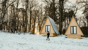 cabanes en bois à la lisière enneigée au soleil