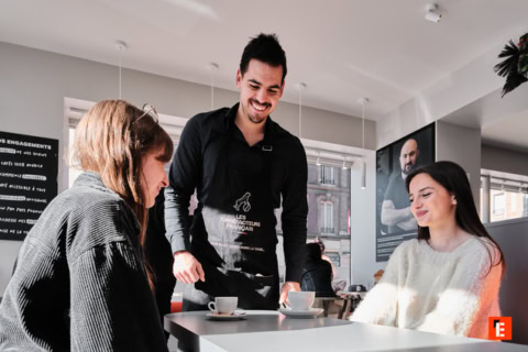 serveur souriant dans un café moderne et lumineux