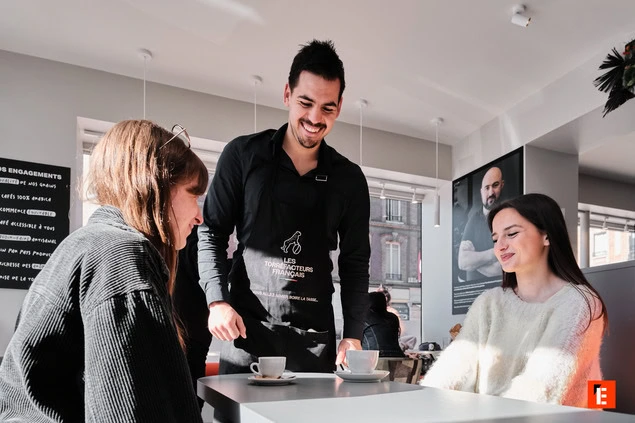 serveur souriant dans un café moderne et lumineux