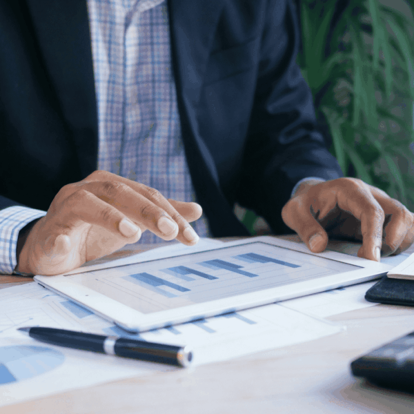 close up on hands of black man calculating something on his tablet