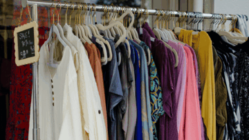 colorful boutique clothing rack with sale sign