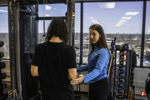 coach sportif corrige la posture en entraînement fonctionnel