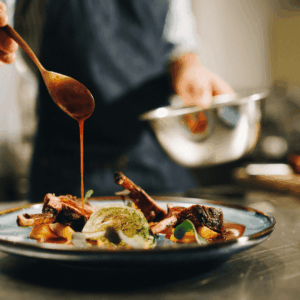 cocinero en restaurante y plato con comida