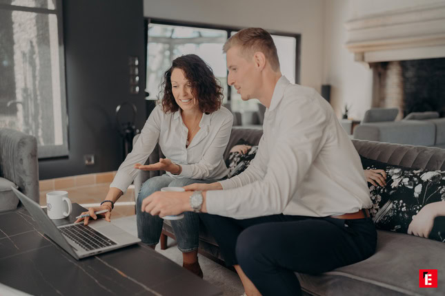 couple collaborant sur laptop dans un salon moderne