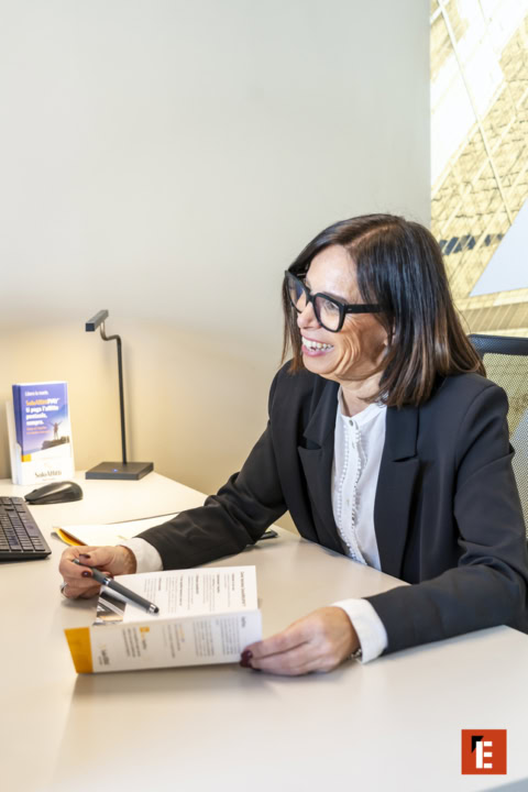 consulente sorridente con brochure in ufficio moderno