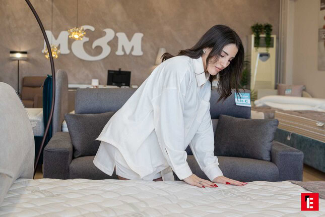 donna prova materasso nel showroom moderno
