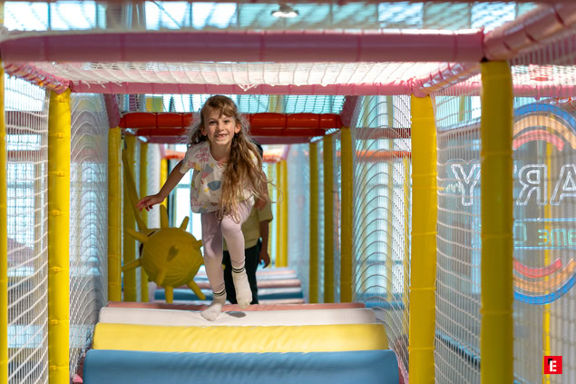 enfant souriante dans tunnel de jeu intérieur coloré