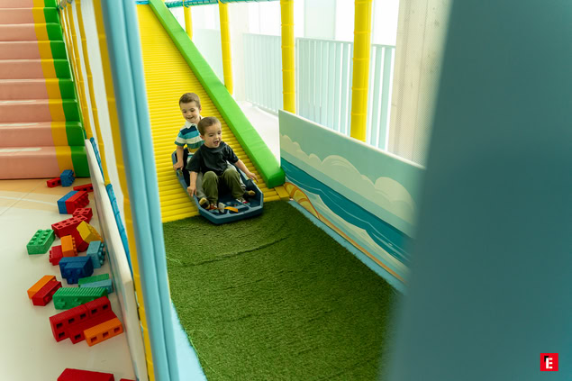 deux enfants sur toboggan intérieur coloré