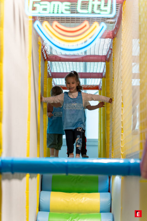 fille souriante dans aire de jeux colorée