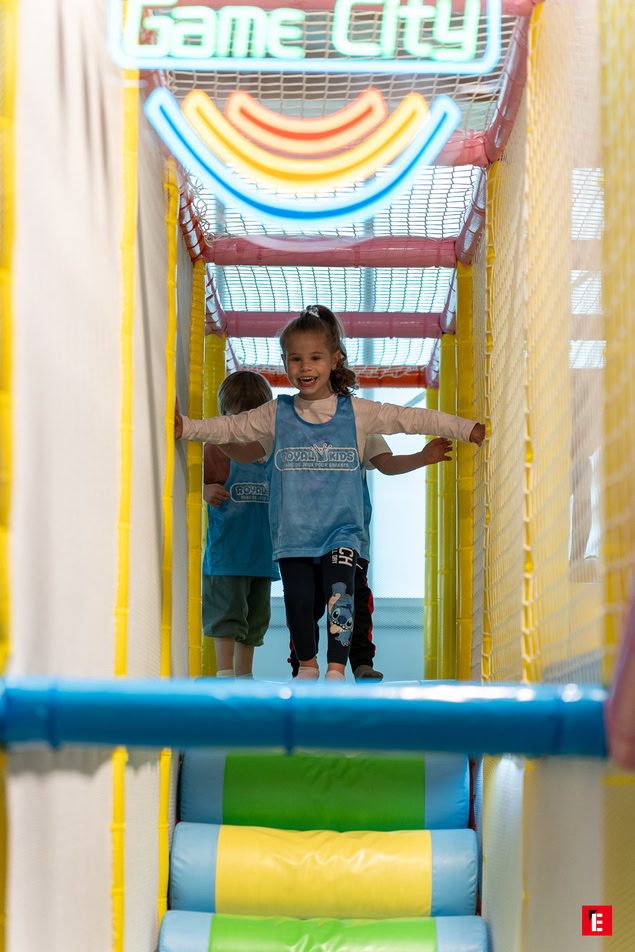 fille souriante dans aire de jeux colorée