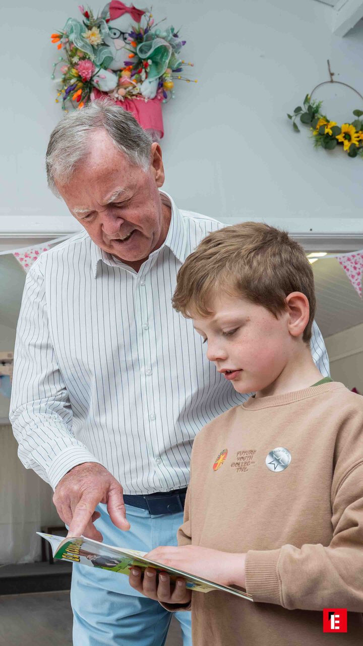 grandfather and grandson reading together at home