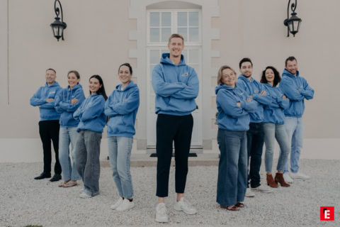 Équipe en hoodies bleus devant un bâtiment
