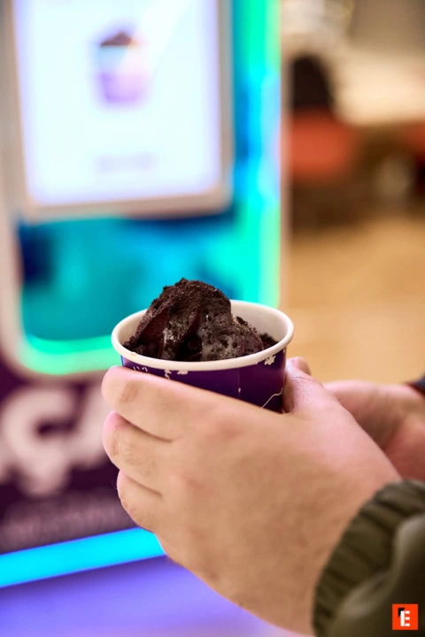 helado negro en taza sostenida por manos