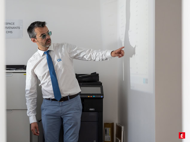 homme au bureau pointant une projection professionnelle
