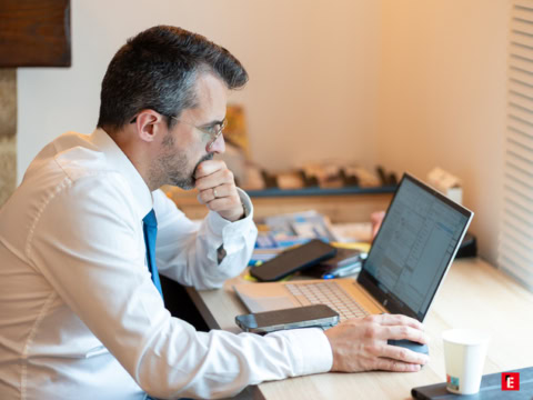 homme concentré au bureau sur ordinateur et tableur
