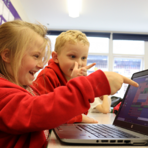 kids collaborating on laptop in classroom