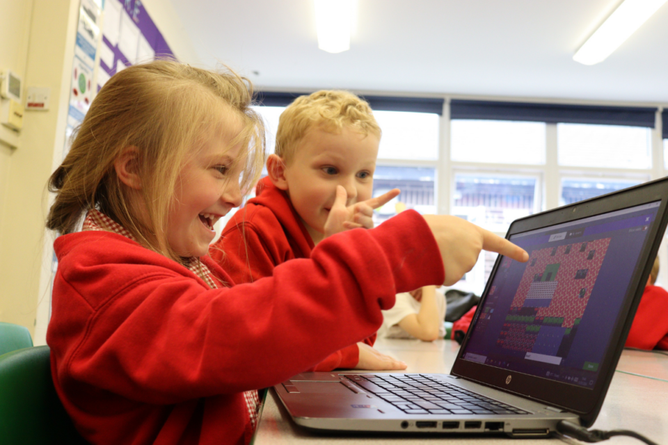 kids collaborating on laptop in classroom
