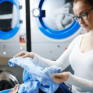 mujer revisando ropa azul en lavandería industrial