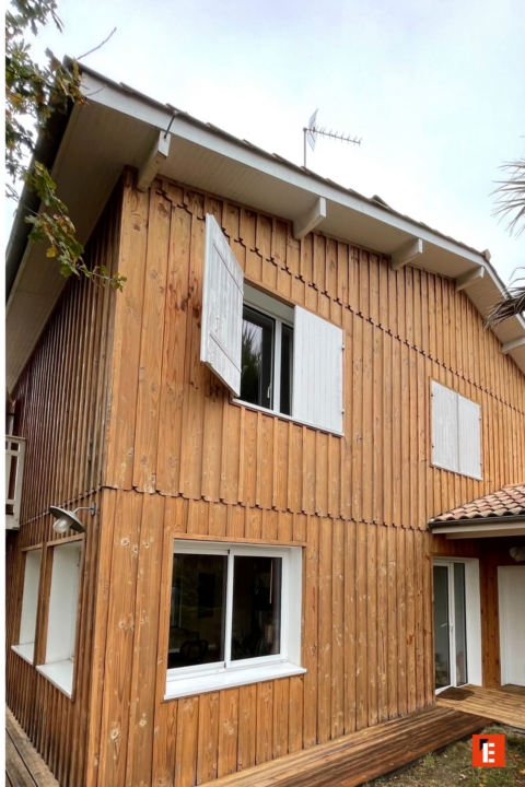 maison en bois avec volets blancs et terrasse