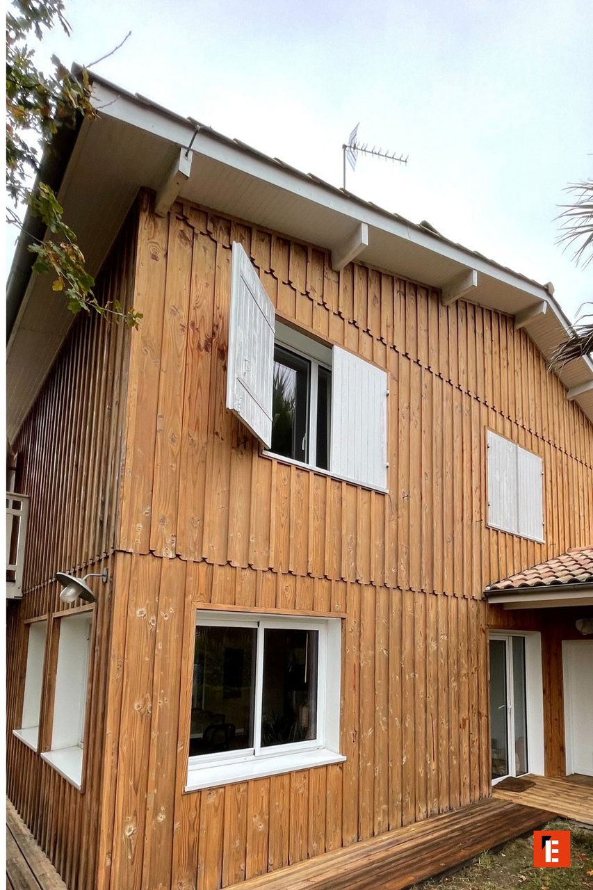 maison en bois avec volets blancs et terrasse