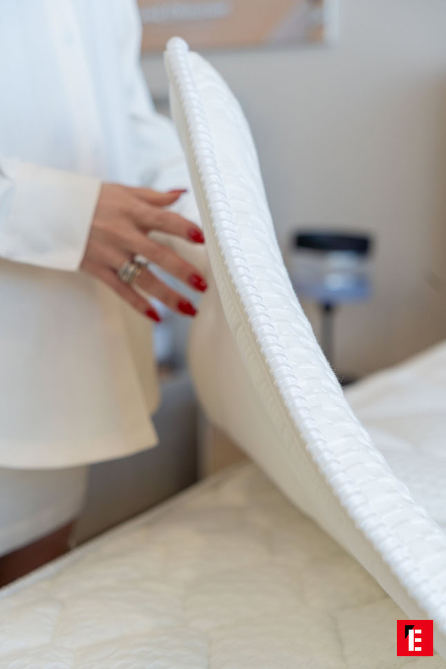 topper materasso trapuntato sollevato: mano con unghie rosse