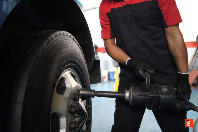 smontaggio ruota: meccanico con chiave a impatto