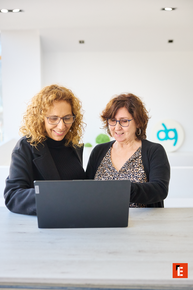 mujeres colaborando en oficina con portátil