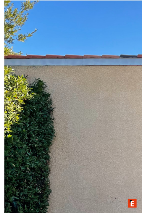 façade beige, haie verte et tuiles rouges