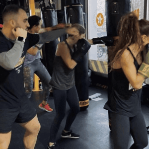 personas entrenando sacos de boxeo