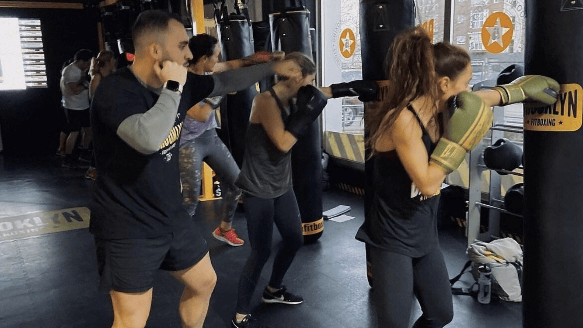 personas entrenando sacos de boxeo