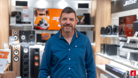 portrait en magasin audio avec enceintes et casques