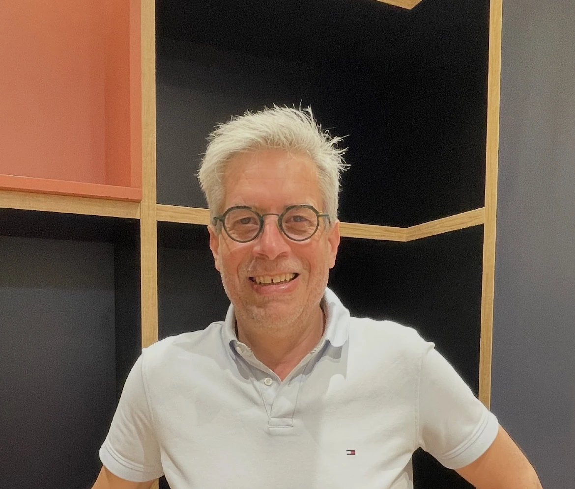 portrait dhomme souriant en polo blanc et lunettes rondes