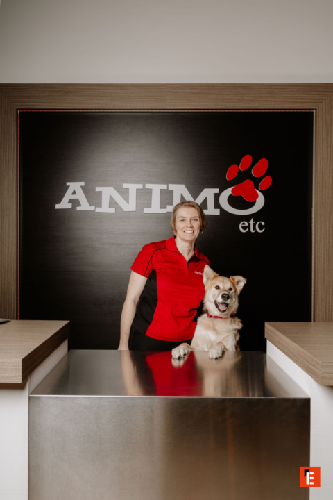 réceptionniste souriante et chien à la clinique vétérinaire animo