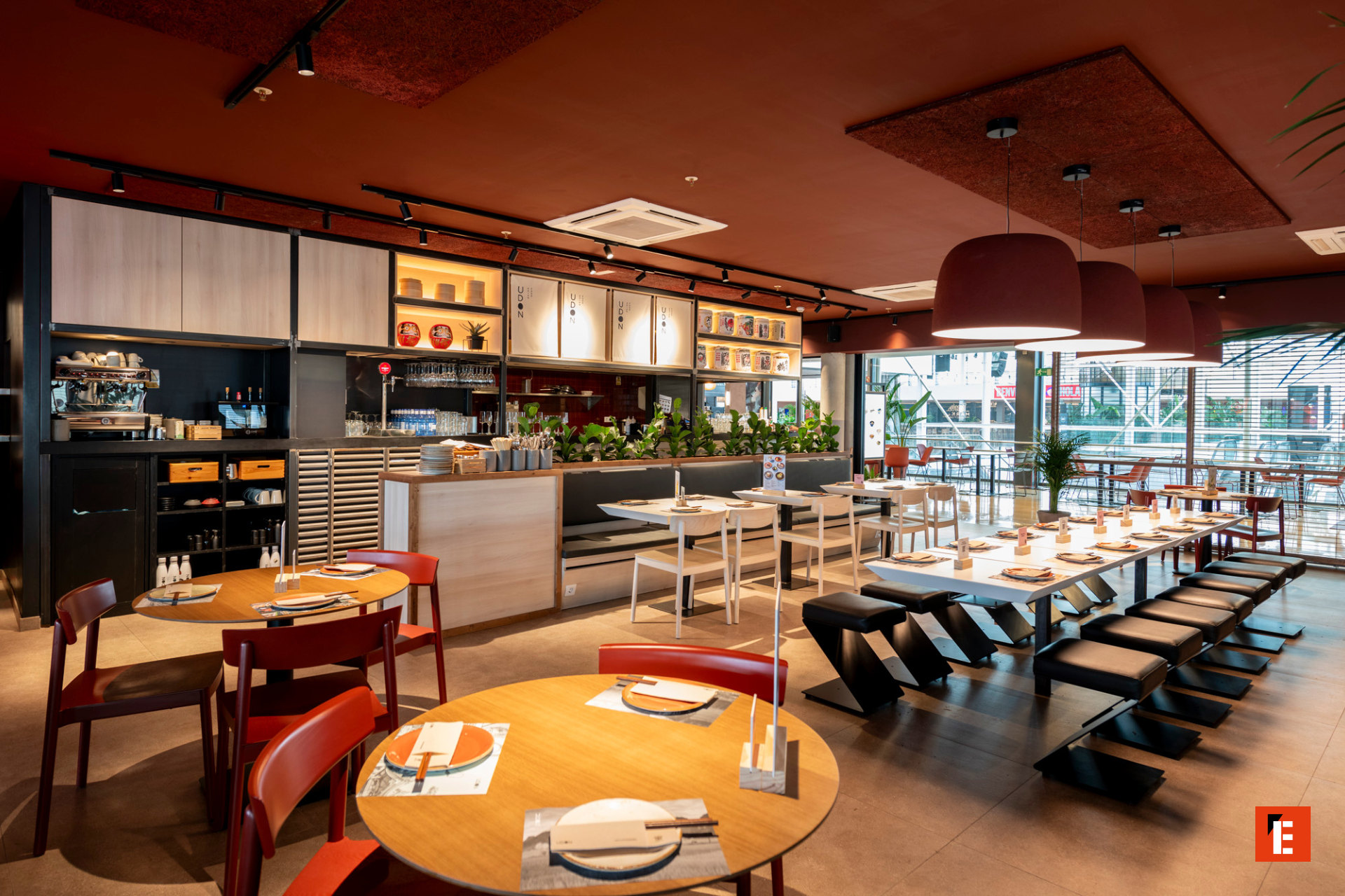 restaurante moderno con mesas comunales y ventanales