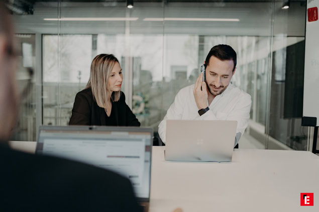 réunion déquipe en bureau vitré avec appel et ordinateurs