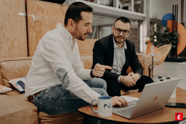 réunion de deux hommes sur canapé en bureau moderne