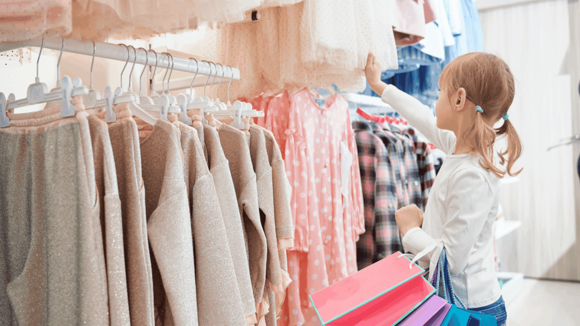 niña comprando ropa infantil en tonos pastel