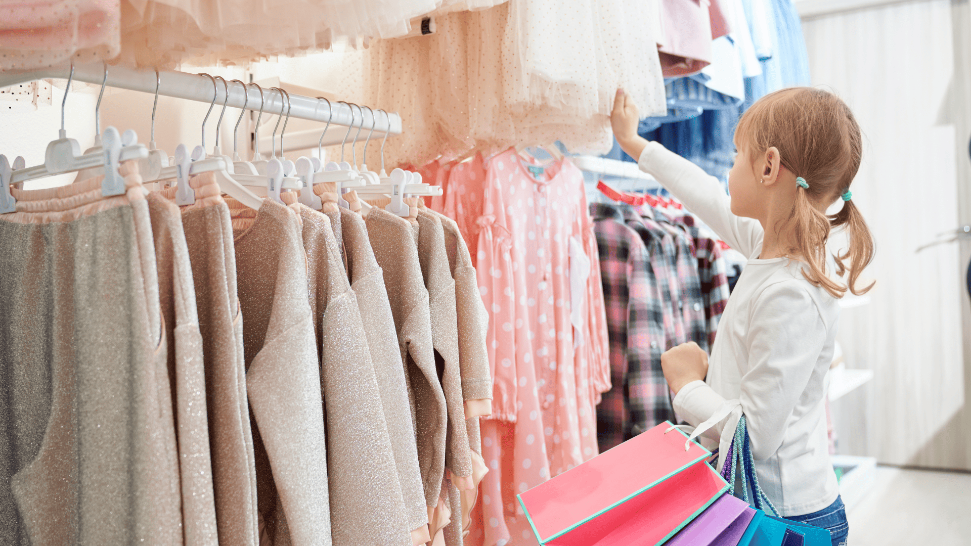 niña comprando ropa infantil en tonos pastel