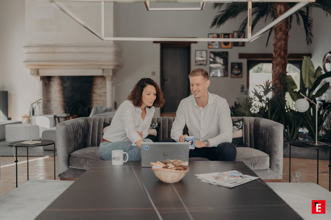 couple dans un salon moderne avec ordinateur portable