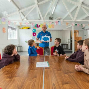 teacher leading boys at community workshop