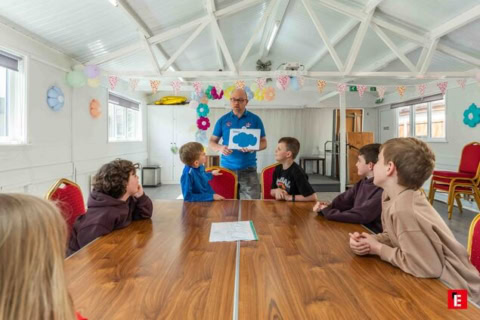 teacher leading boys at community workshop
