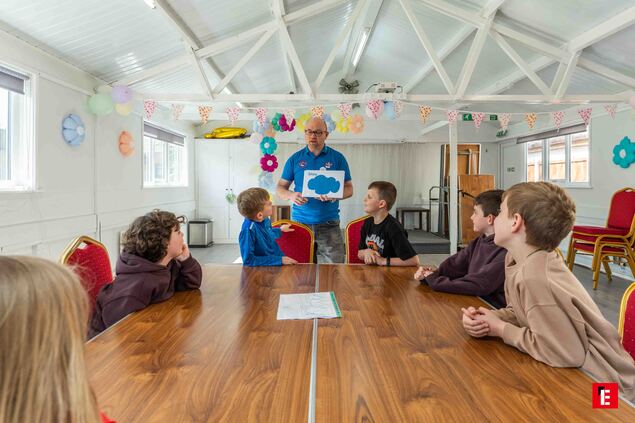 teacher leading boys at community workshop